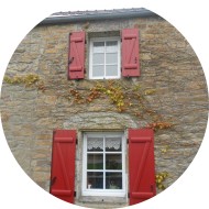 volets battants en aluminium à barres et écharpes - rouge brun - sur maison en pierre et fenêtres avec petits bois incorporés volets battants en aluminium à barres et écharpes - rouge brun - sur maison en pierre